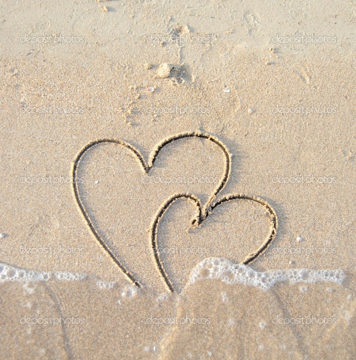 Two connected hearts drawn on wet sand